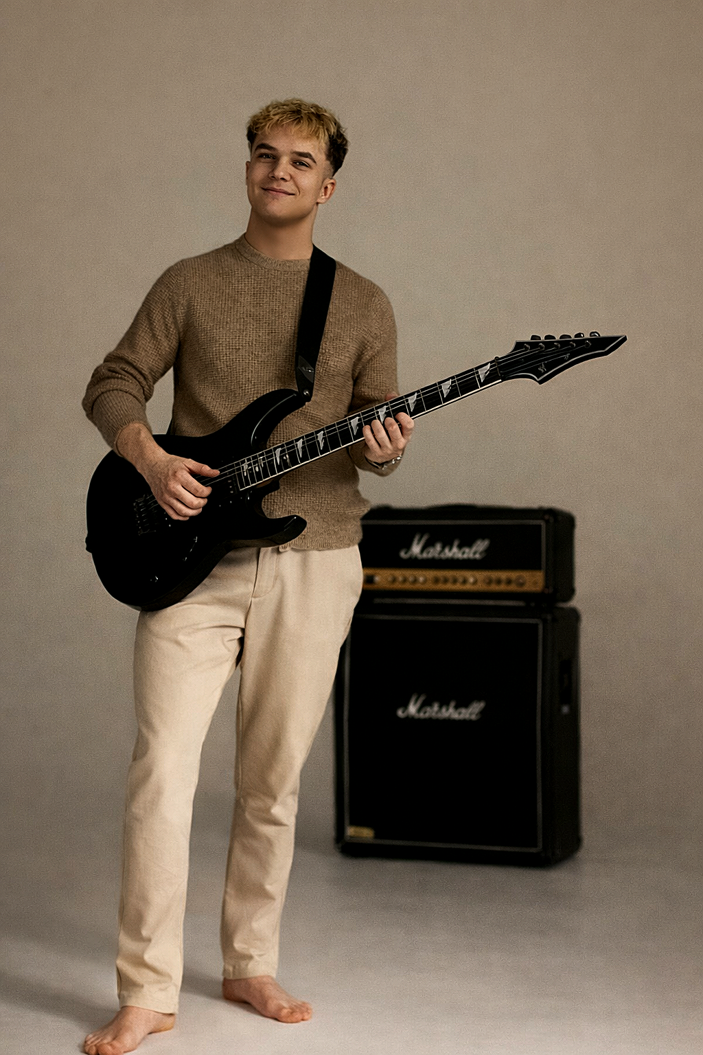 Rostyslav holding an electric guitar near amplifiers